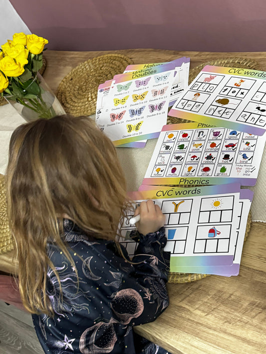 Child practising KS1 activities on various Busby Busy Books learning mats