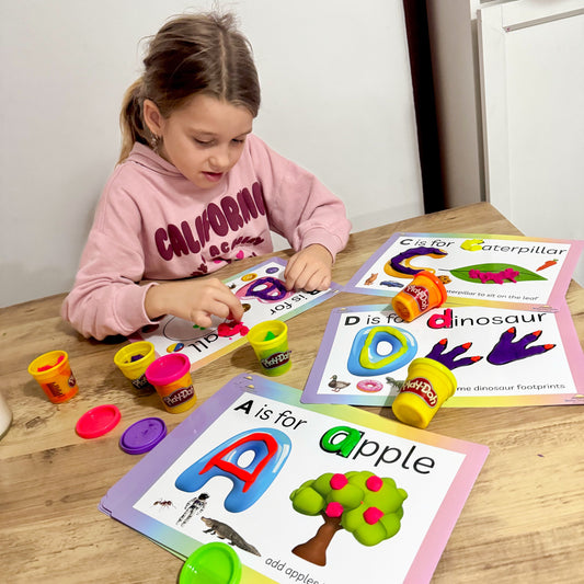Child shaping playdough on a Busby Busy Books alphabet playdough mat